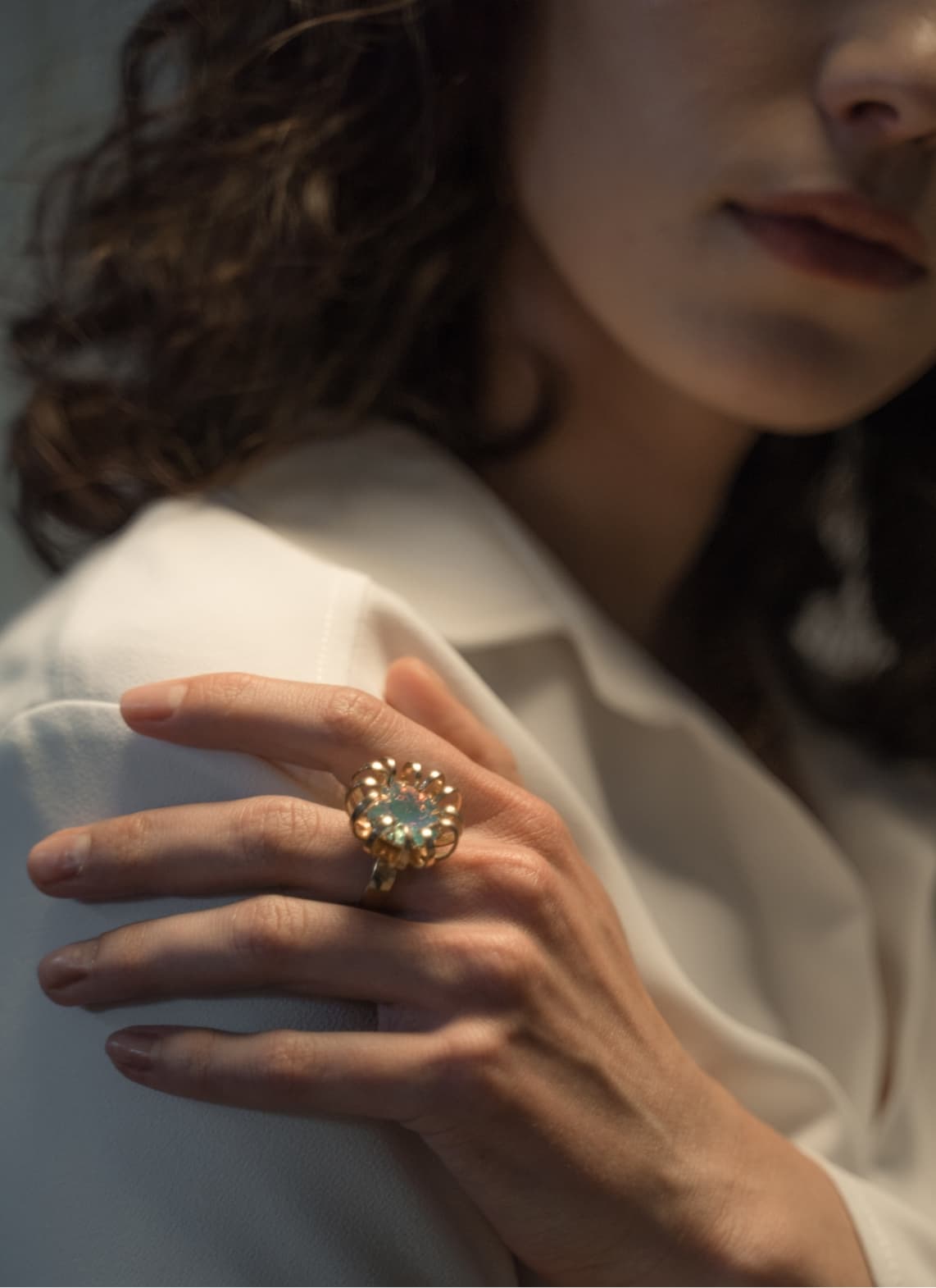 Eine Dame in weißem Blazer trägt einen effektvollen Statement-Ring.